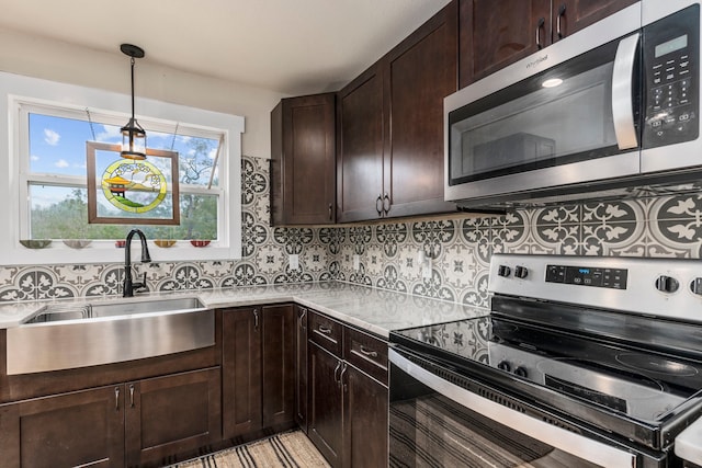 kitchen with dark brown cabinetry, sink, pendant lighting, and appliances with stainless steel finishes