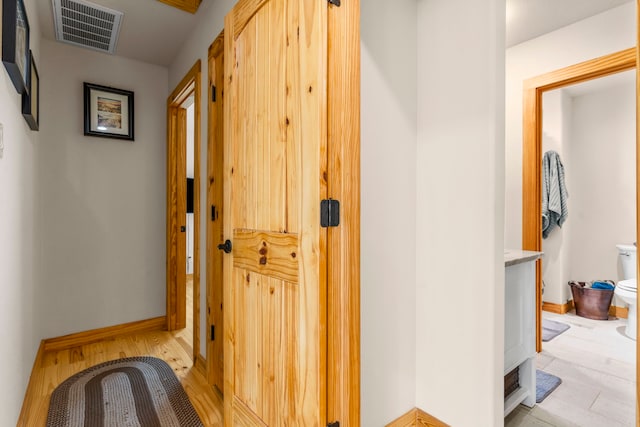 corridor with light hardwood / wood-style floors