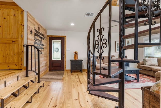 entrance foyer with light hardwood / wood-style floors and wood walls