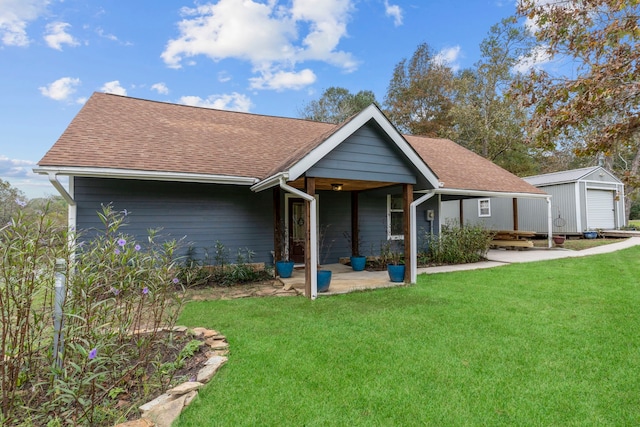 view of front facade featuring a garage, an outdoor structure, and a front yard