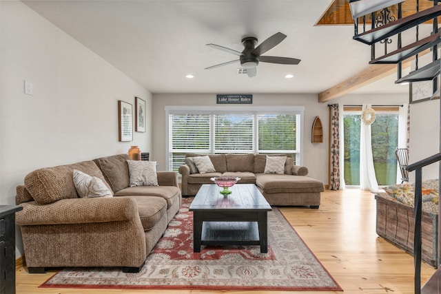 living room featuring ceiling fan, wood-type flooring, and beamed ceiling