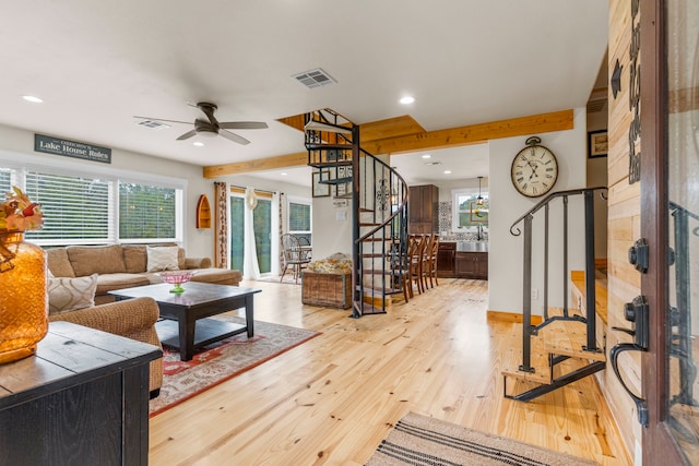 living room with beamed ceiling, ceiling fan, and light hardwood / wood-style flooring