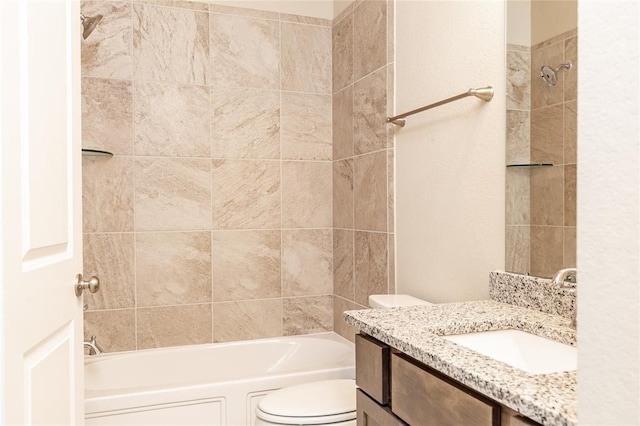 full bathroom with vanity, tiled shower / bath, and toilet