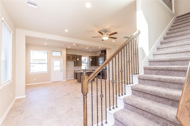 stairs featuring plenty of natural light and ceiling fan