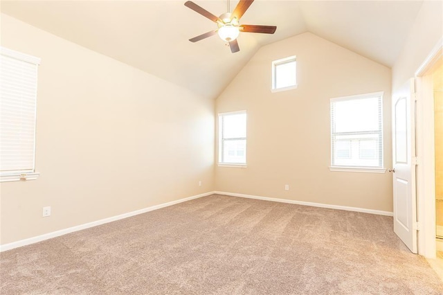 carpeted empty room featuring ceiling fan, a healthy amount of sunlight, and vaulted ceiling