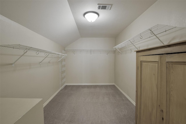 walk in closet with lofted ceiling and carpet floors