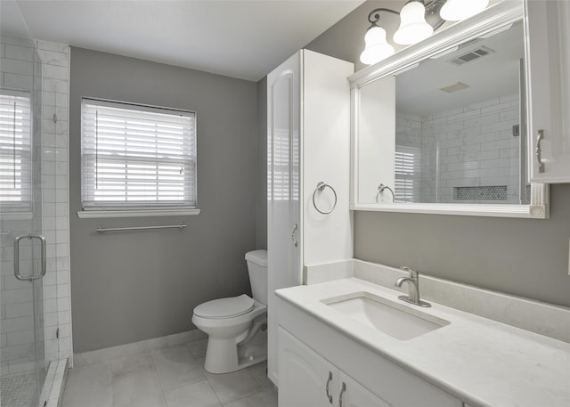 bathroom with tile patterned floors, toilet, a shower with shower door, and vanity