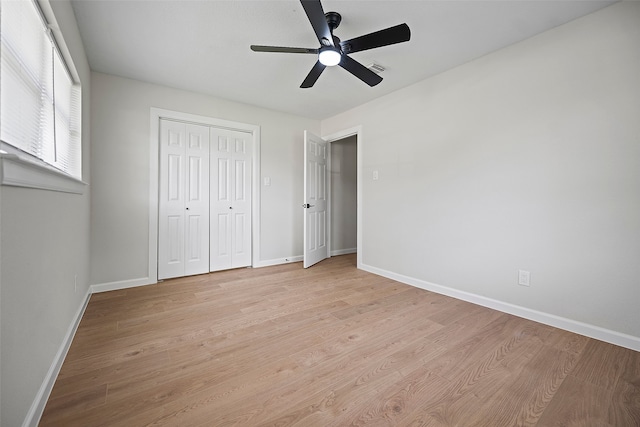 unfurnished bedroom featuring light hardwood / wood-style flooring, a closet, and ceiling fan