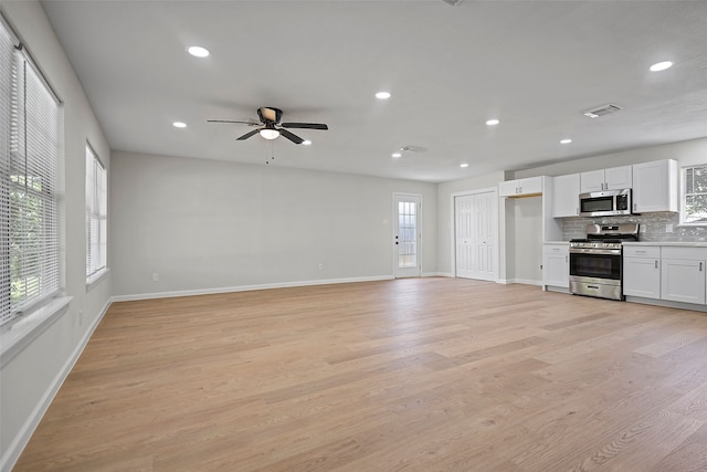 unfurnished living room featuring ceiling fan, a healthy amount of sunlight, and light hardwood / wood-style floors