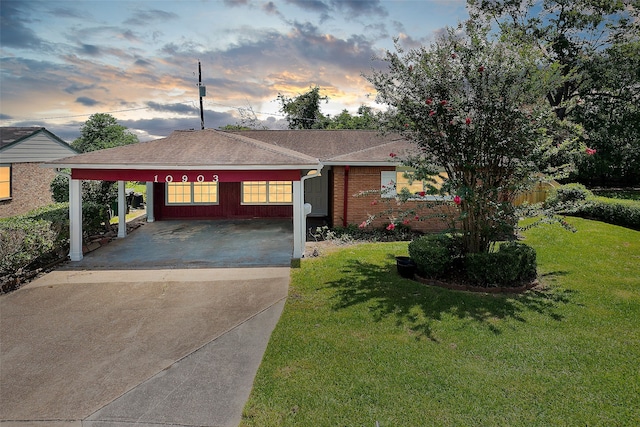 ranch-style house with a carport and a yard