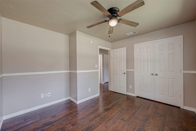 unfurnished bedroom with ceiling fan, dark hardwood / wood-style flooring, and a closet