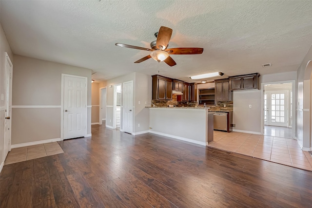 unfurnished living room with a textured ceiling, ceiling fan, and light wood-type flooring