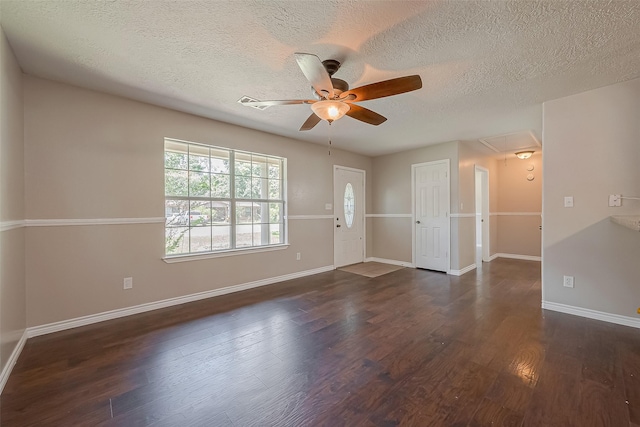 unfurnished room with ceiling fan, dark wood-type flooring, and a textured ceiling