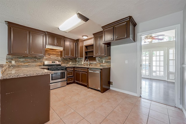 kitchen with sink, light tile patterned floors, appliances with stainless steel finishes, ceiling fan, and decorative backsplash