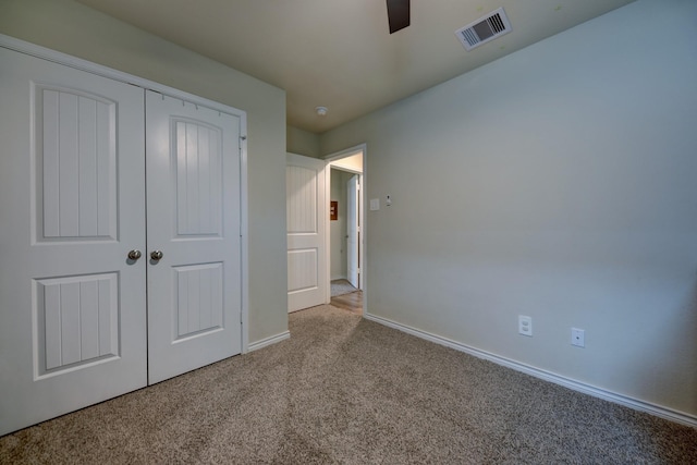 unfurnished bedroom with ceiling fan, light colored carpet, and a closet