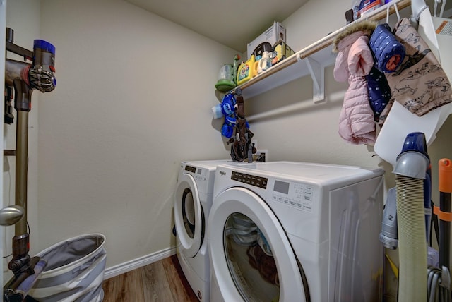 laundry room with wood-type flooring and separate washer and dryer