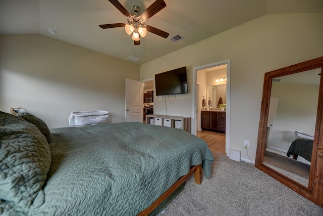 carpeted bedroom featuring connected bathroom, vaulted ceiling, and ceiling fan