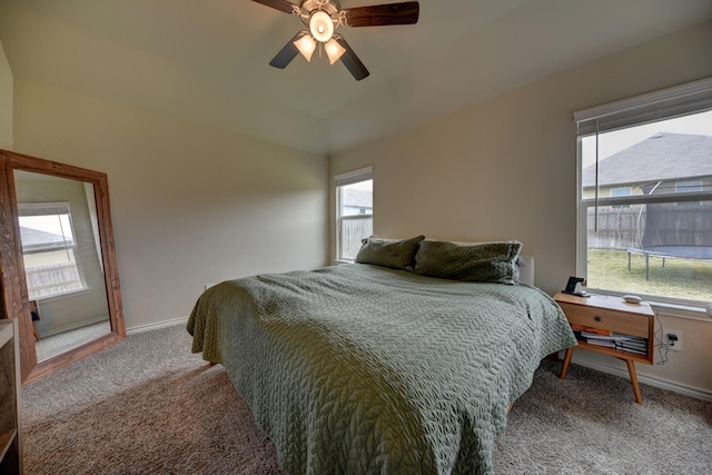 bedroom with ceiling fan, carpet floors, and multiple windows