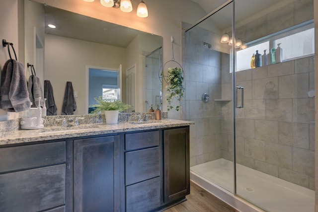 bathroom with an enclosed shower, hardwood / wood-style floors, vanity, and vaulted ceiling