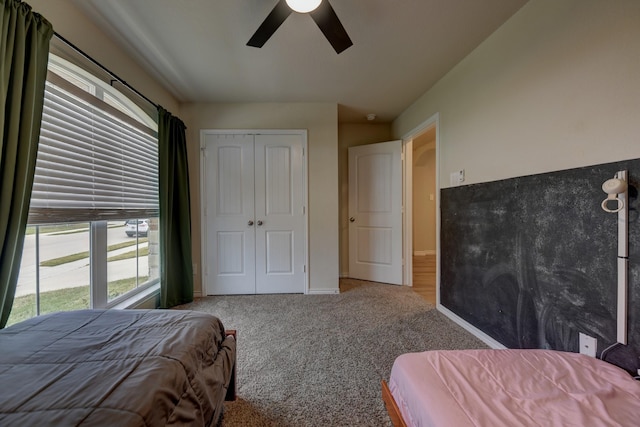 carpeted bedroom featuring ceiling fan and a closet