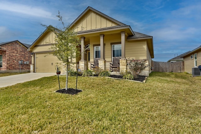 craftsman-style home featuring a garage, central AC unit, covered porch, and a front yard