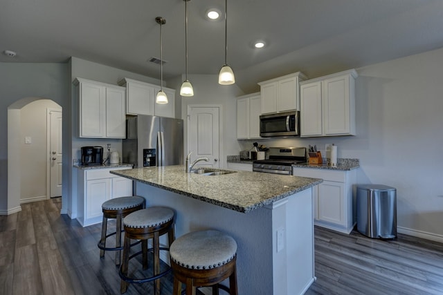 kitchen featuring white cabinetry, stainless steel appliances, stone countertops, and pendant lighting