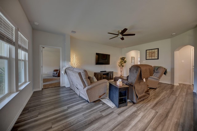 living room featuring wood-type flooring and ceiling fan