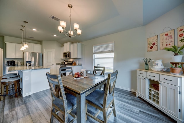 dining area featuring dark hardwood / wood-style floors and an inviting chandelier