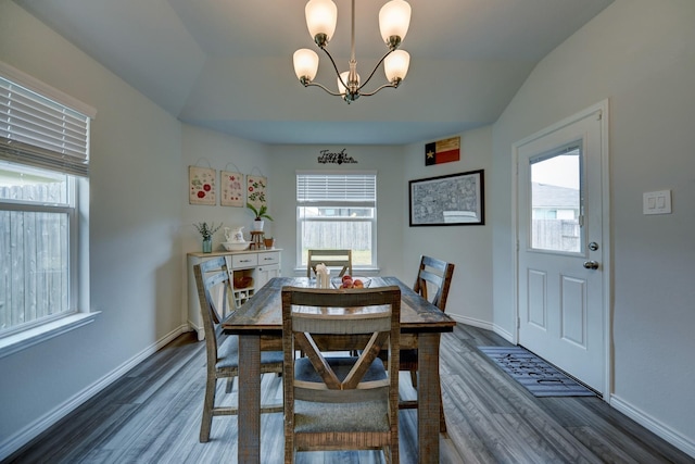 dining space featuring vaulted ceiling, dark wood-type flooring, and a chandelier