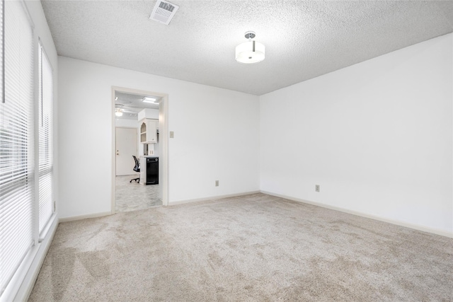 unfurnished room featuring carpet flooring and a textured ceiling