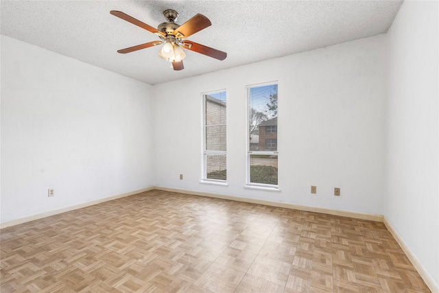 unfurnished room with ceiling fan, a textured ceiling, and light parquet flooring