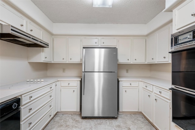 kitchen with white cooktop, a textured ceiling, stainless steel refrigerator, double oven, and white cabinets