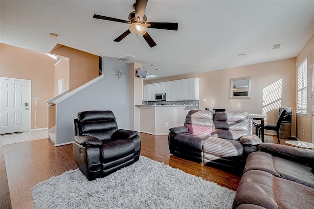 living room featuring light hardwood / wood-style flooring and ceiling fan