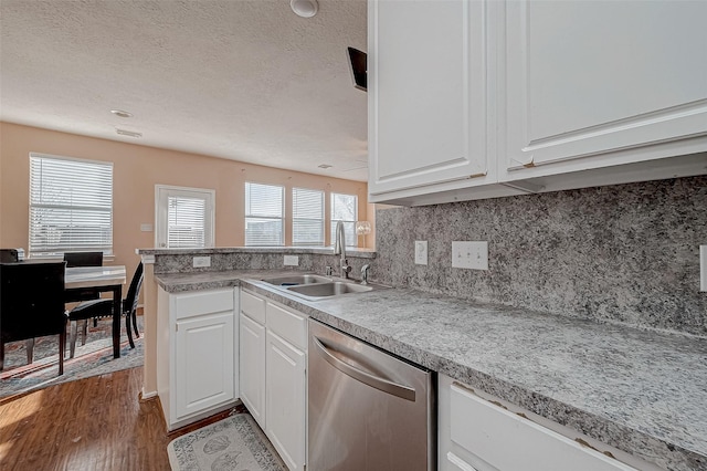 kitchen with dishwasher, sink, white cabinets, and kitchen peninsula