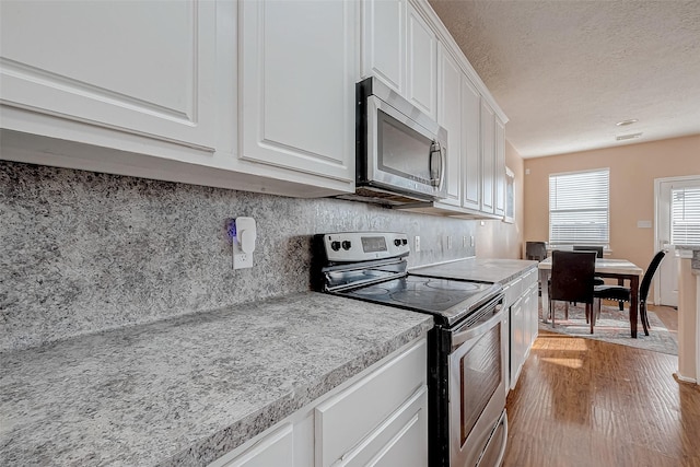 kitchen with tasteful backsplash, stainless steel appliances, and white cabinets