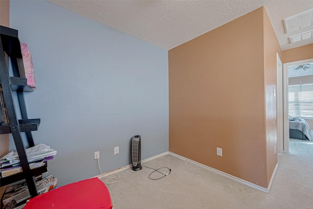 carpeted office featuring vaulted ceiling and a textured ceiling