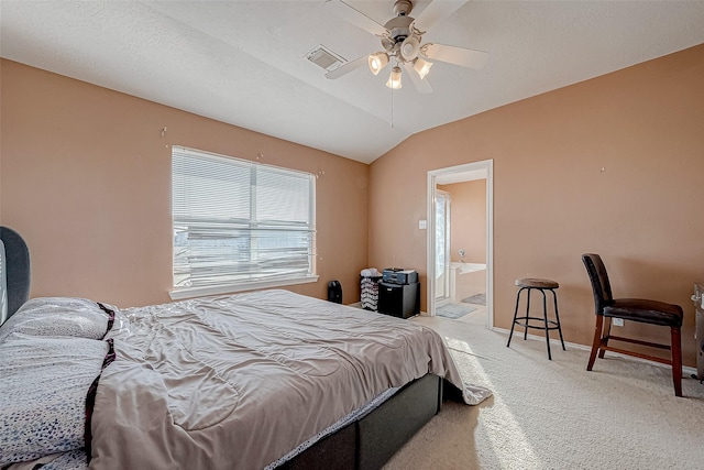 carpeted bedroom featuring lofted ceiling, ceiling fan, and ensuite bath