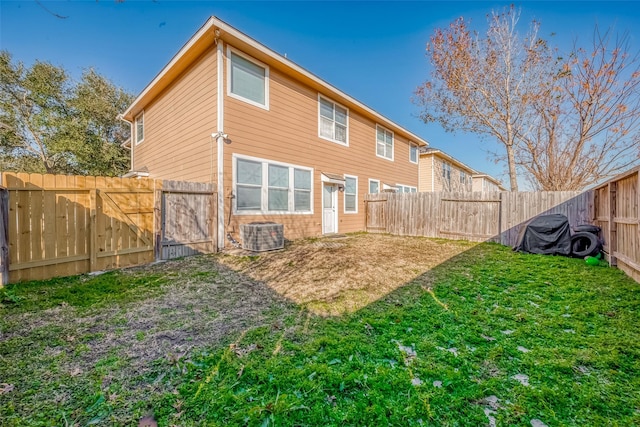 rear view of property with a yard and central AC