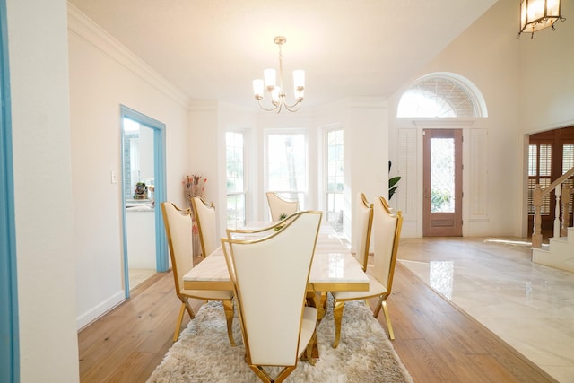 dining space with a notable chandelier, crown molding, and light hardwood / wood-style flooring