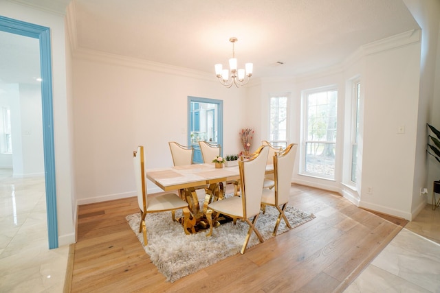 dining room with ornamental molding, a chandelier, and light hardwood / wood-style floors