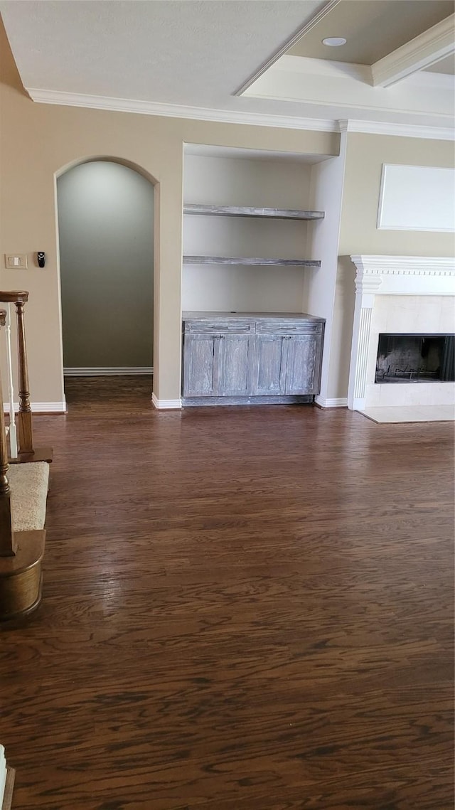 unfurnished living room with crown molding, dark wood-type flooring, and built in features