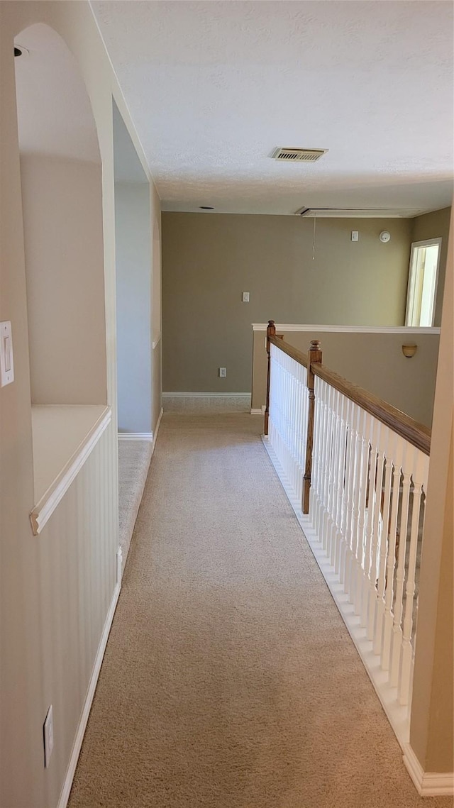 hallway featuring light colored carpet