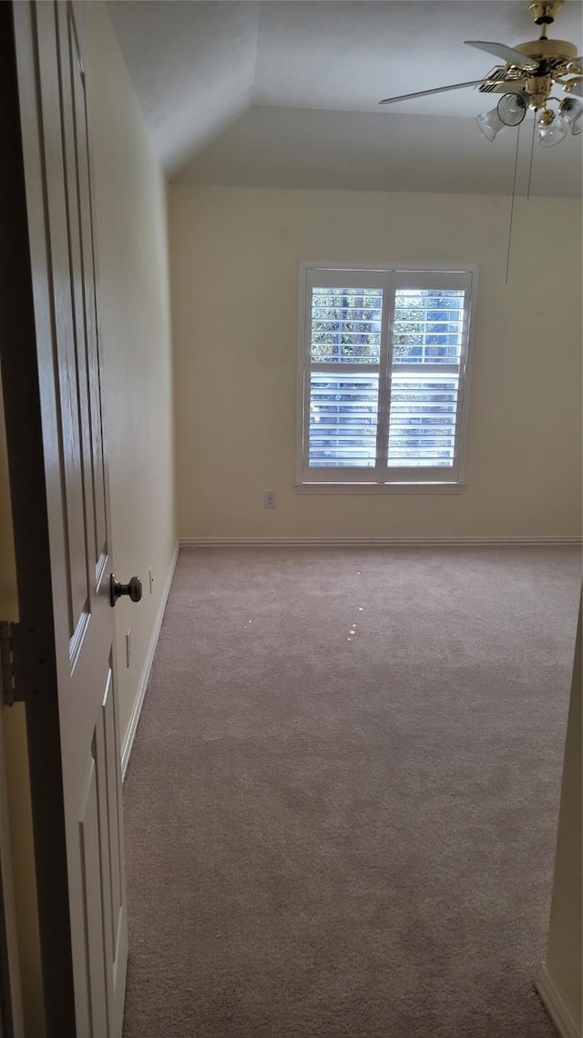 carpeted empty room with vaulted ceiling and ceiling fan