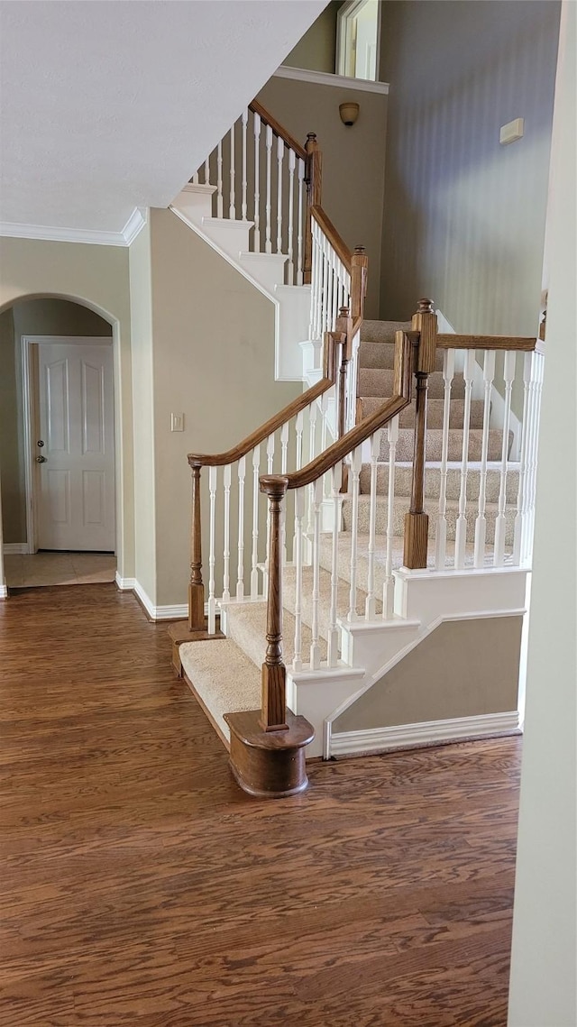 staircase featuring crown molding and hardwood / wood-style flooring