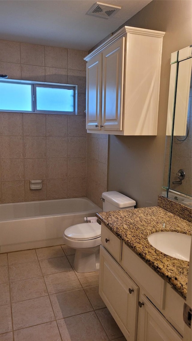 full bathroom with vanity, tiled shower / bath, tile patterned floors, and toilet