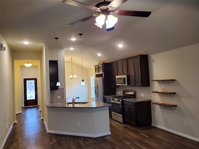 kitchen with sink, stone countertops, decorative light fixtures, appliances with stainless steel finishes, and dark hardwood / wood-style flooring