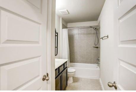 full bathroom with vanity, tile patterned floors, toilet, and shower / bathtub combination with curtain