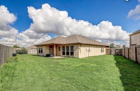 rear view of house with a lawn and a patio