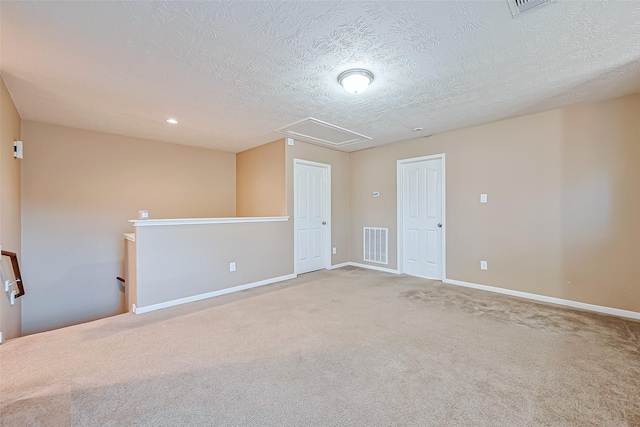 carpeted spare room featuring a textured ceiling