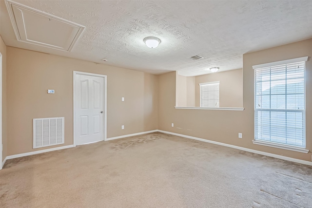 spare room featuring carpet flooring and a textured ceiling